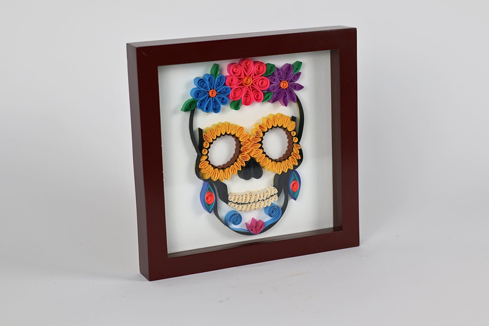 Cuadro con calavera blanca, corona azul y flores de colores