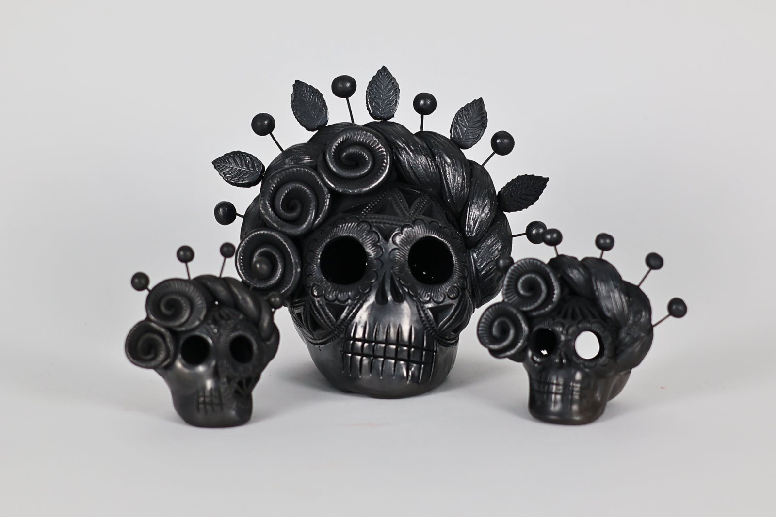Composición de calaveras negras con corona floral calada, vista 1 de 5