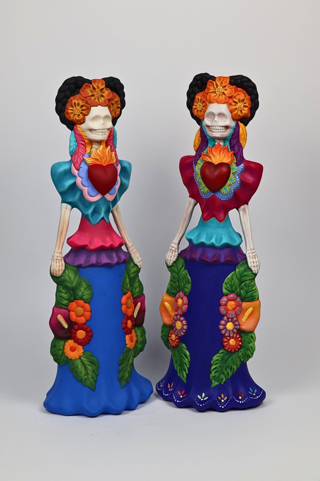 Pareja de catrinas altas con vestidos florales de colores, vista 1 de 2