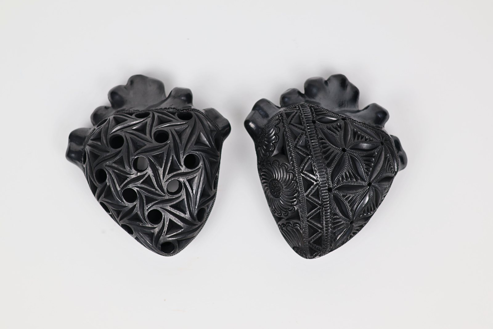 Pareja de corazones negros con ornamentos florales calados, vista 1 de 2