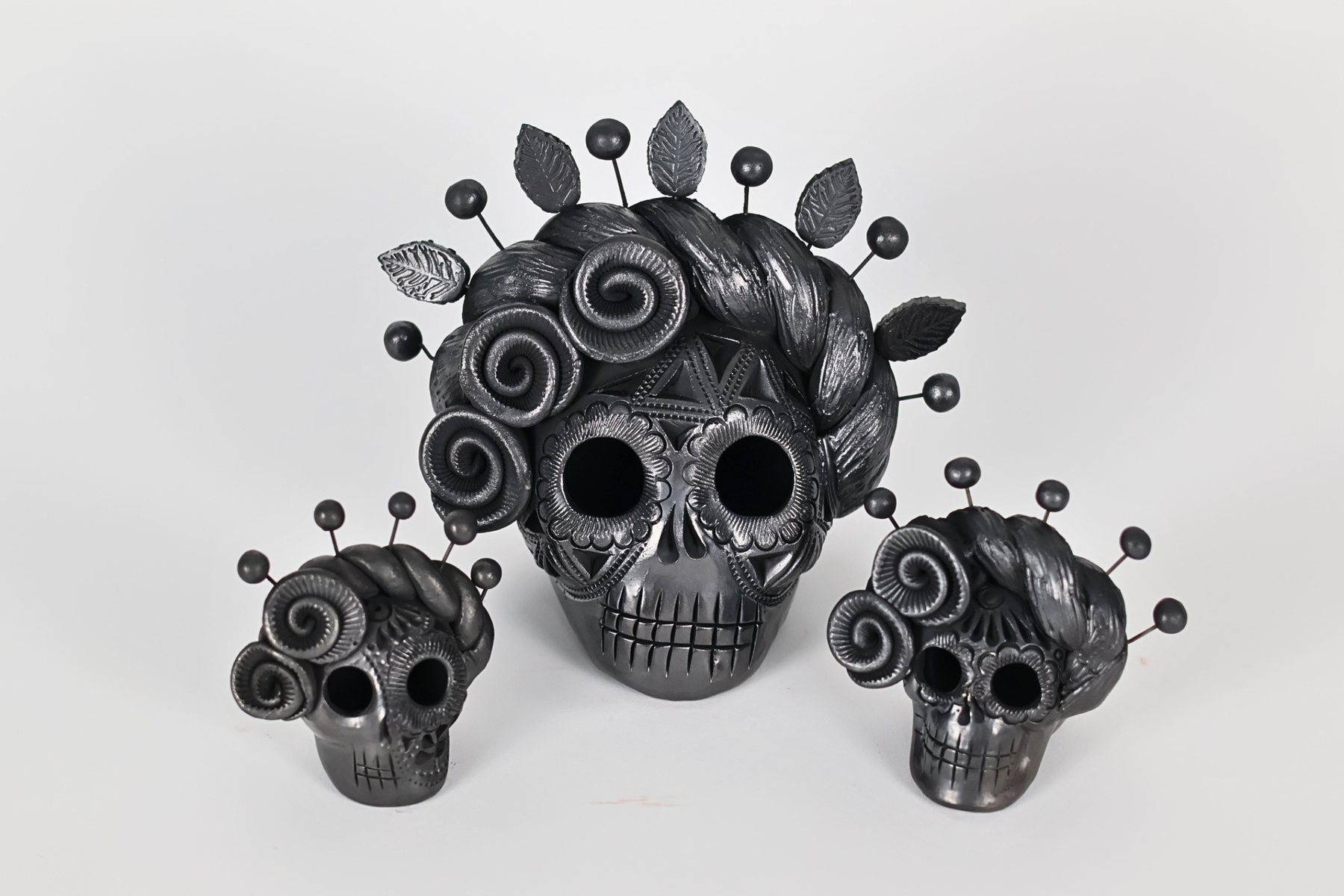 Calavera de cerámica pintada a mano en naranja con flores verdes